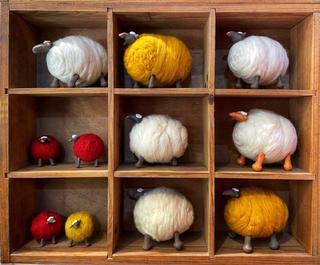 Wool Sheeep Woolen sheep of various sizes in a wooden box with dividers